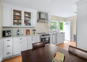 Remodeled kitchen with white cabinets, tile backsplash and granite counter tops