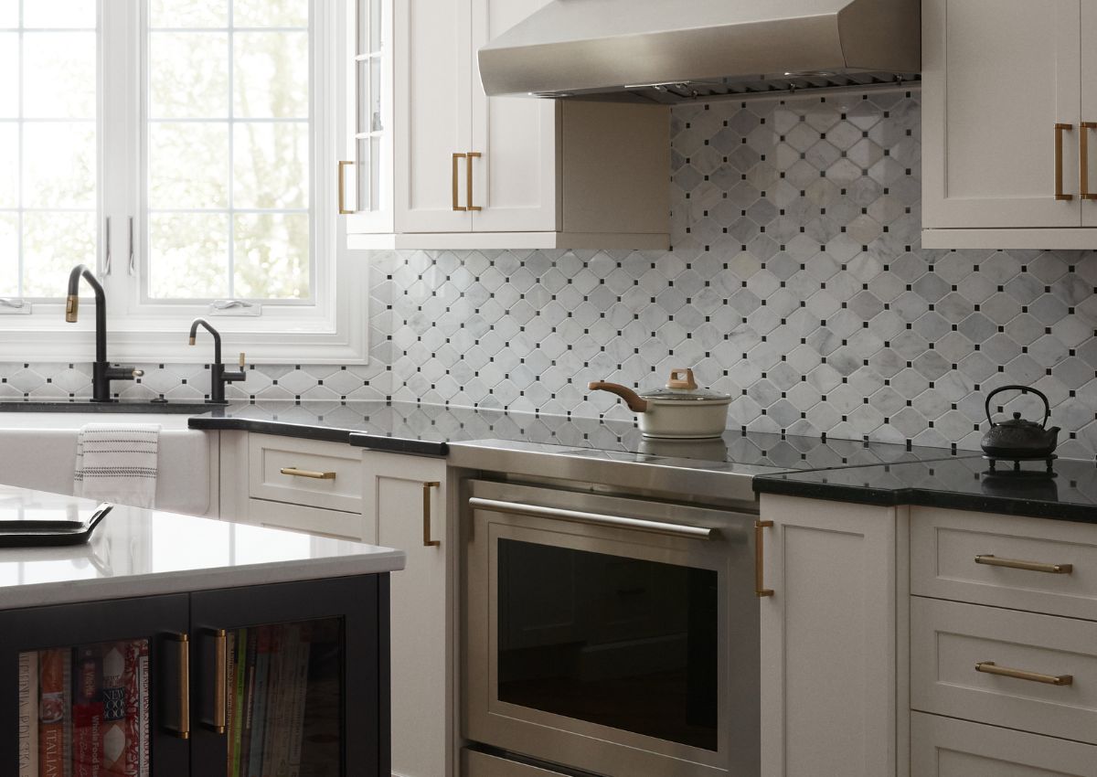 Image of a renovated kitchen in Ambler with white cabinets and high-end stove