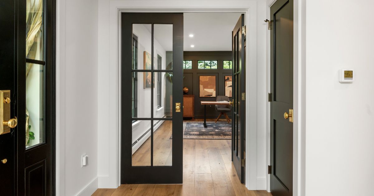 Black painted french doors as the entrance to a renovated home office