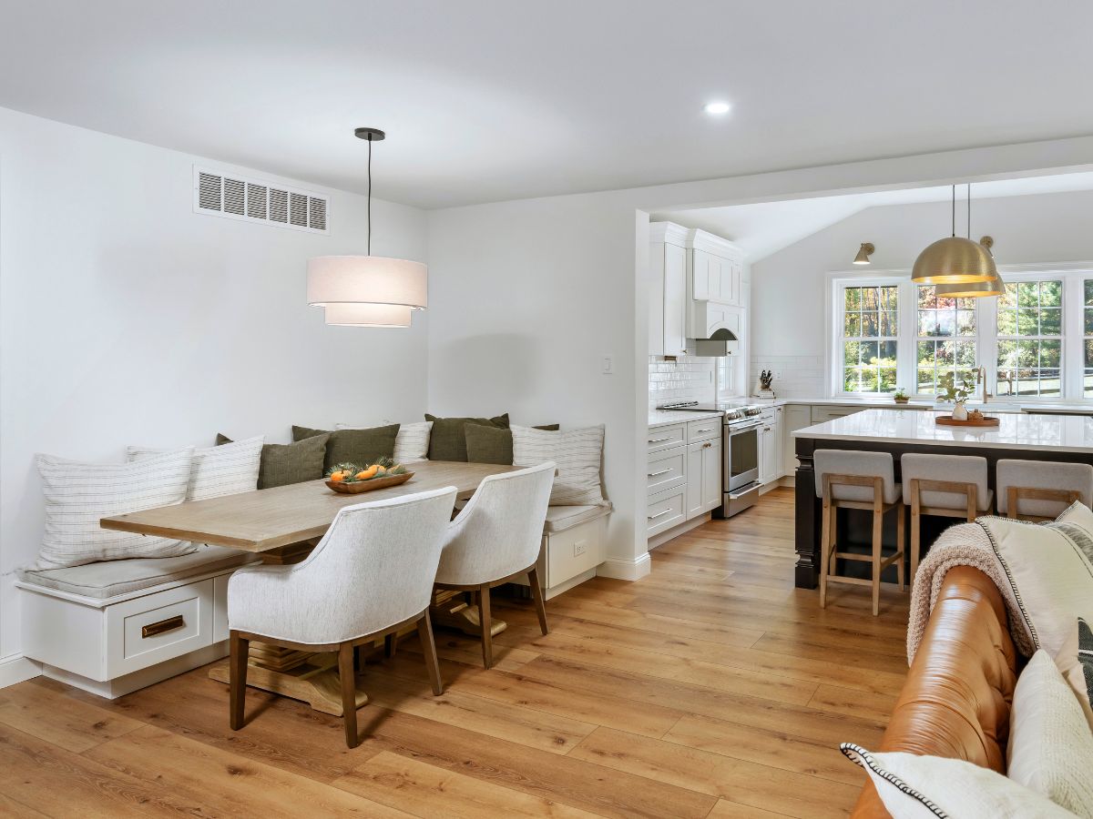 Renovated kitchen with white cabinets and custom banquette