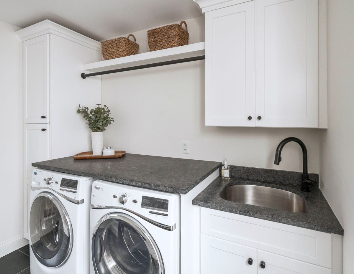 Remodeled laundry room with white shelving and sink.