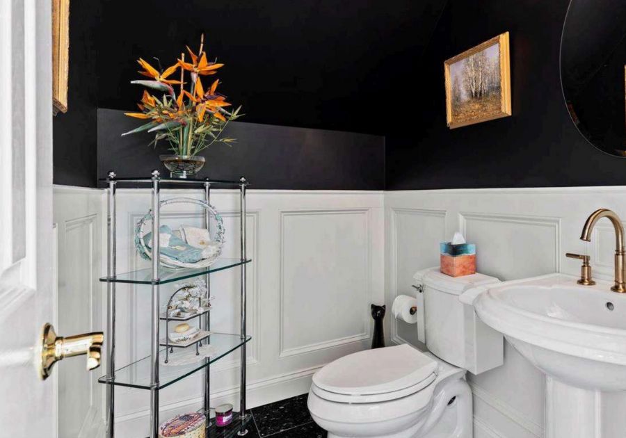 Remodeled powder room with pedestal sink and black wallpaper.