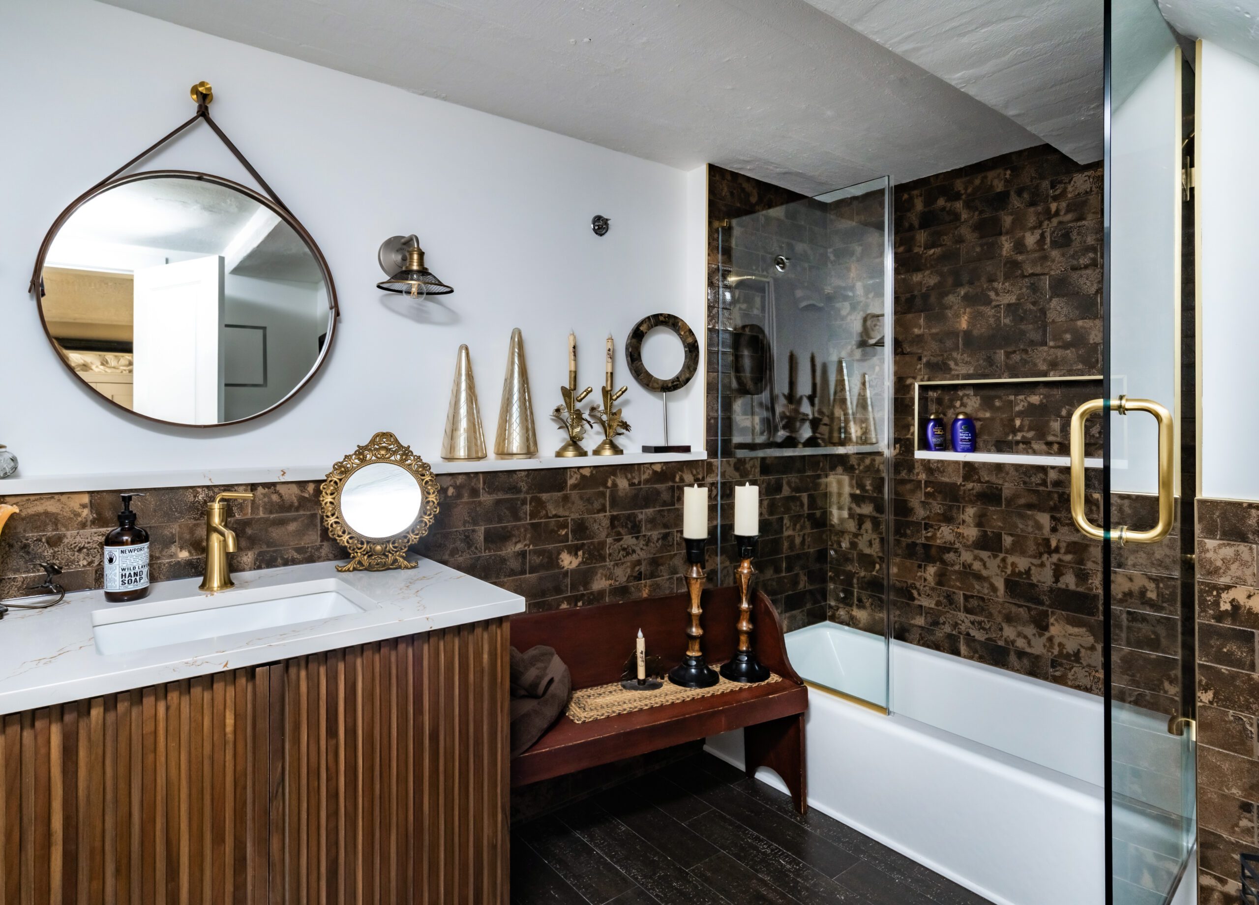 Custom bathroom with round mirror and wood vanity
