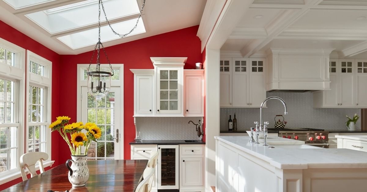 White cabinetry in a renovated kitchen with red accent wall