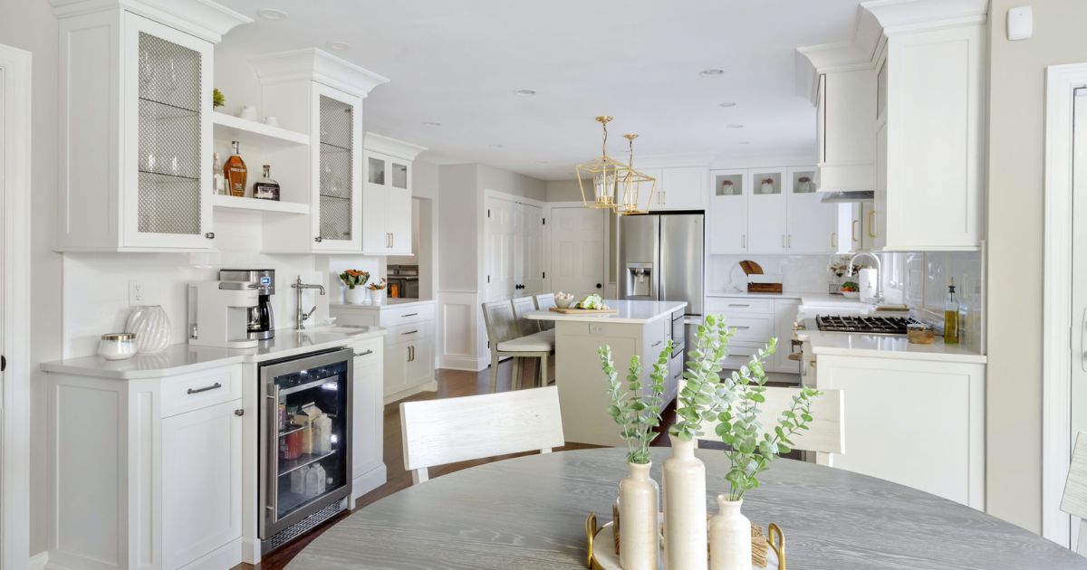 White kitchen cabinets in a renovated kitchen with a wine fridge.