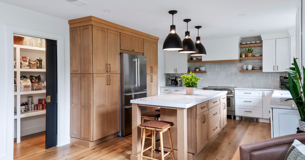 Natural wood cabinetry with hidden pantry in a renovated kitchen