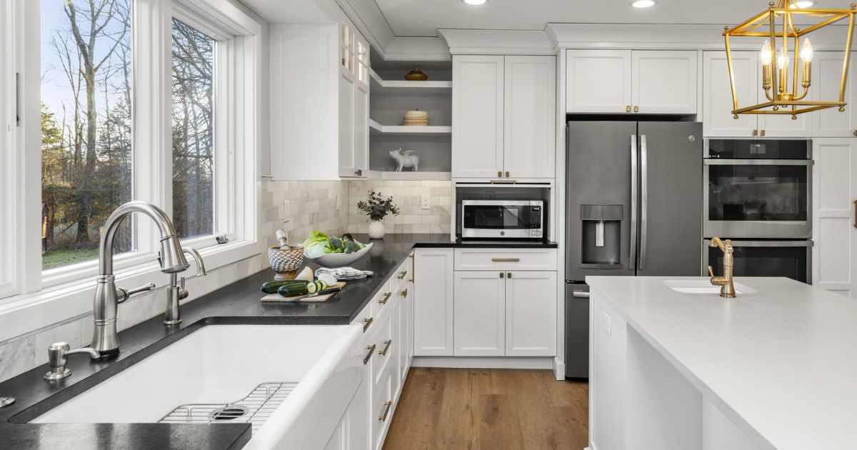 Renovated kitchen with large white island and white cabinetry