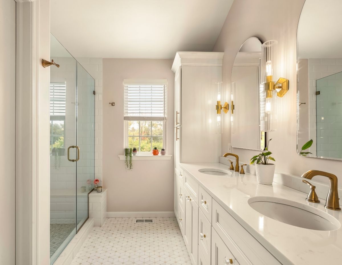 White renovated bathroom with double sink vanity and gold fixtures